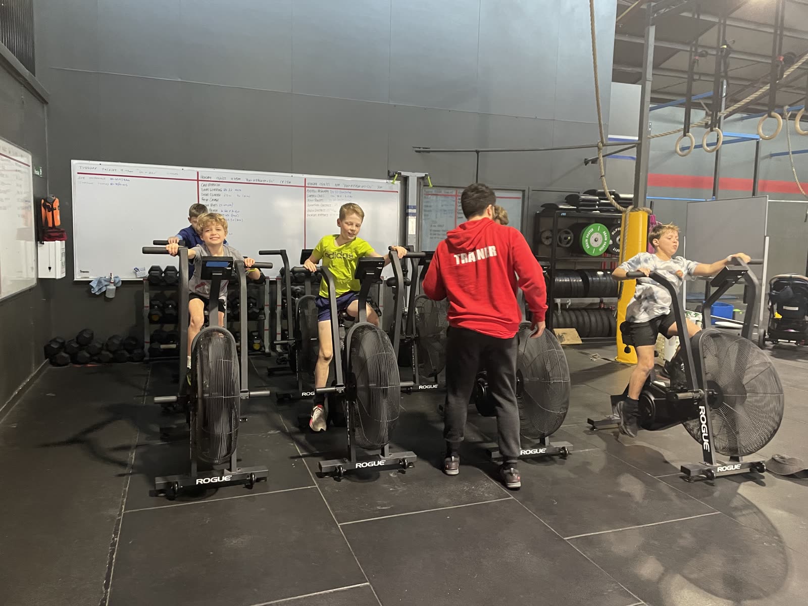 CrossFit Brisbane kids riding bike ergs during a supervised kids class