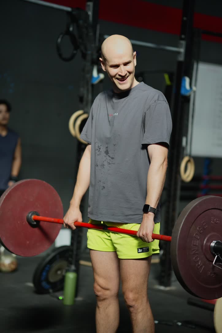 CrossFit Brisbane member smiling while holding a barbell during training