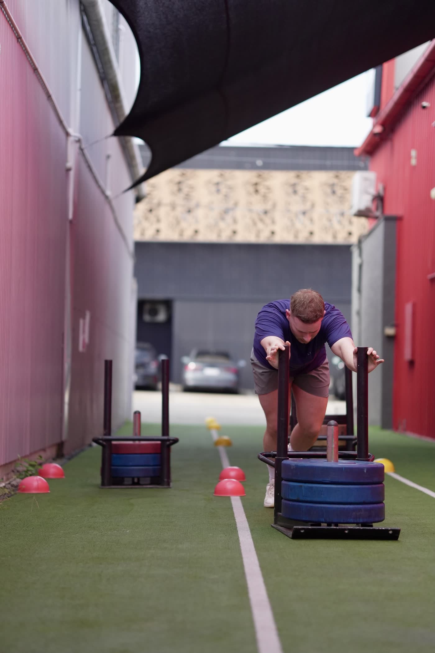 CrossFit Brisbane athlete pushing a sled during hybrid training